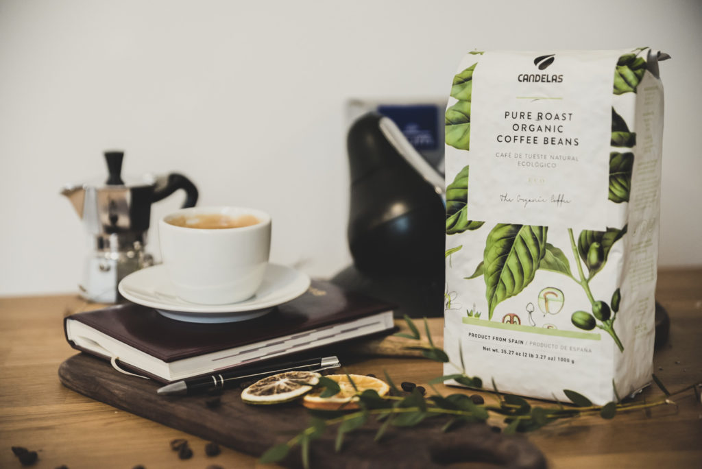 kawa organiczna w białym opakowaniu obok białej filżanki