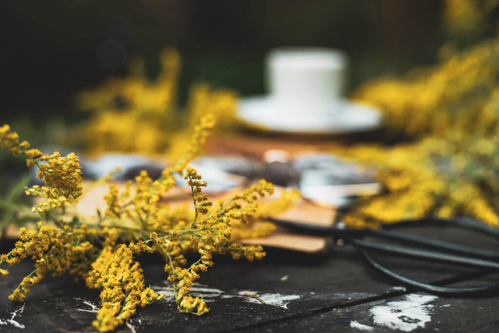 drewniany stół i żółte jesienne kwiaty