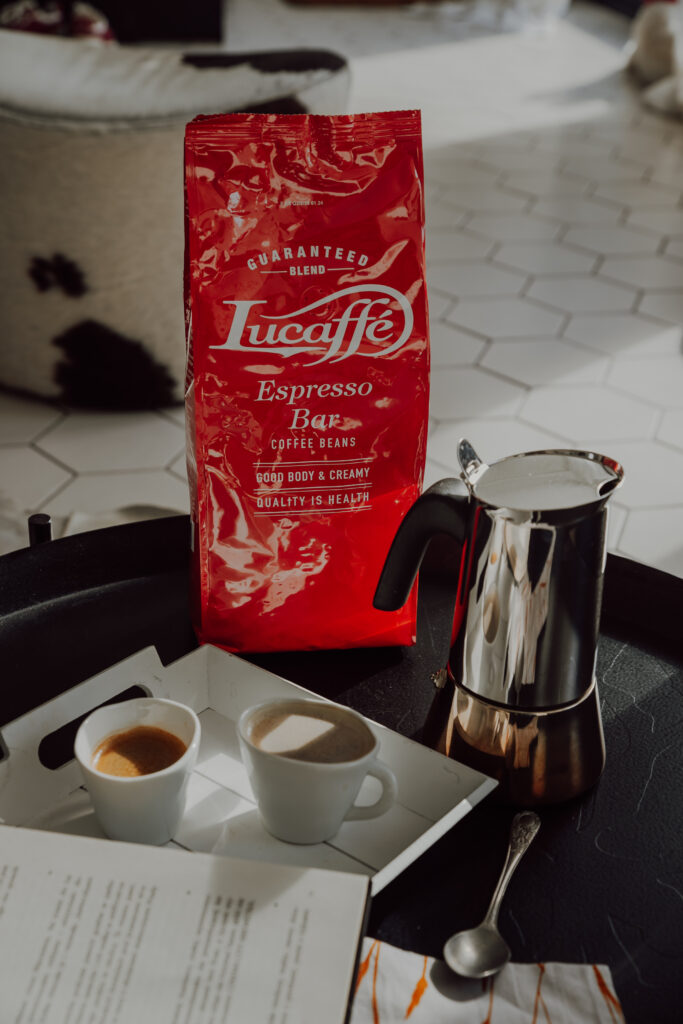 Kawa Lucaffe Espresso Bar na stoliku kawowym z filiżankami espresso i kawiarka