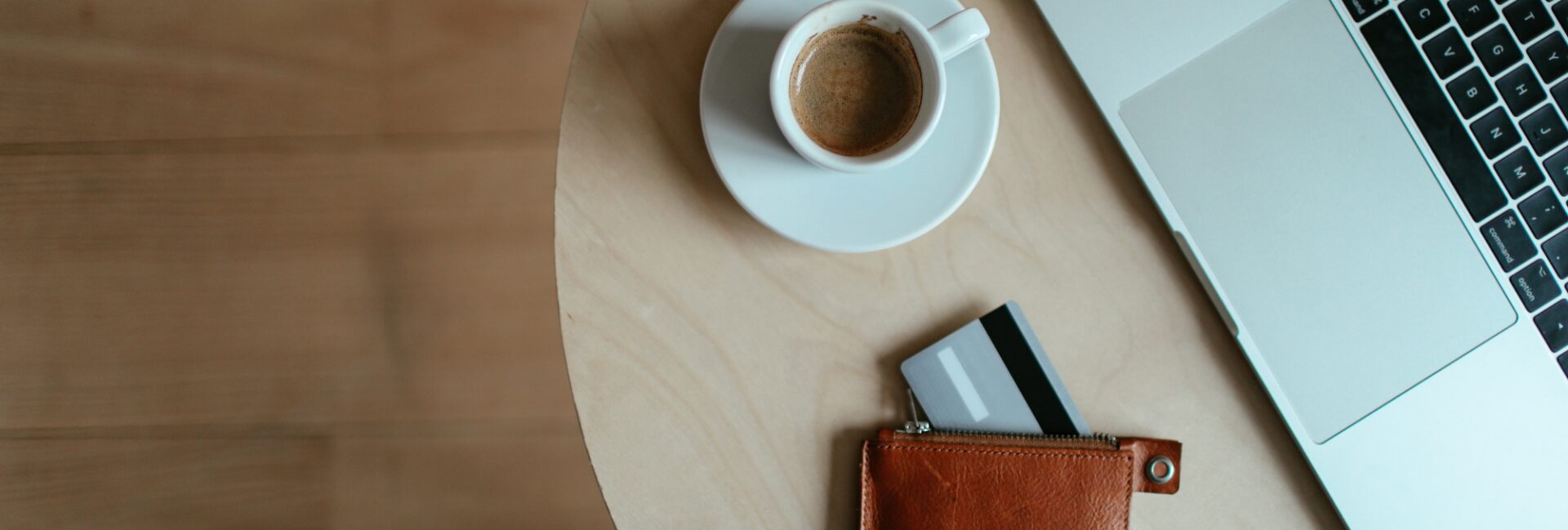 stolik z filiżanką espresso, portfelem i laptopem