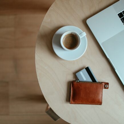 stolik z filiżanką espresso, portfelem i laptopem