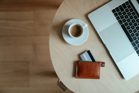 stolik z filiżanką espresso, portfelem i laptopem