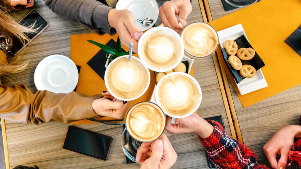 filiżanki z cappuccino stukające się ze sobą